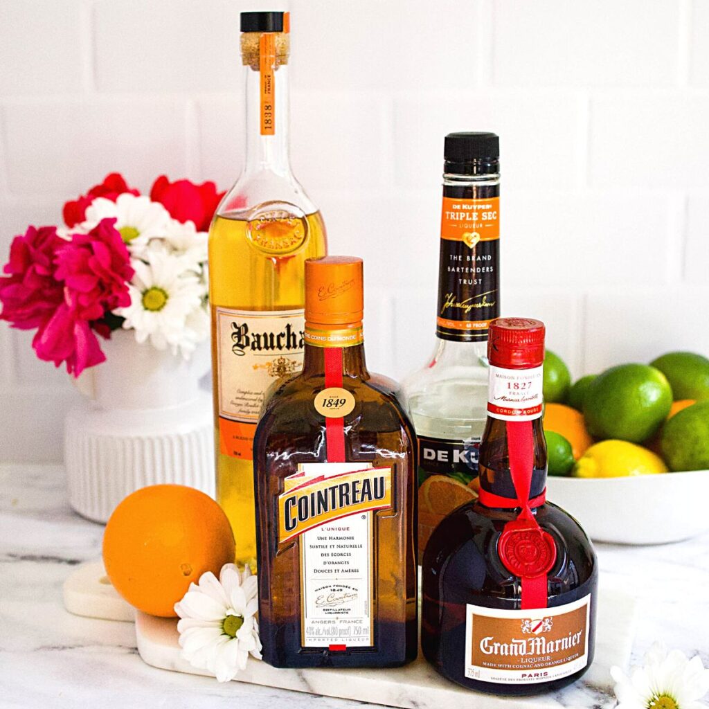 A variety of orange liqueurs for making margaritas on a table.