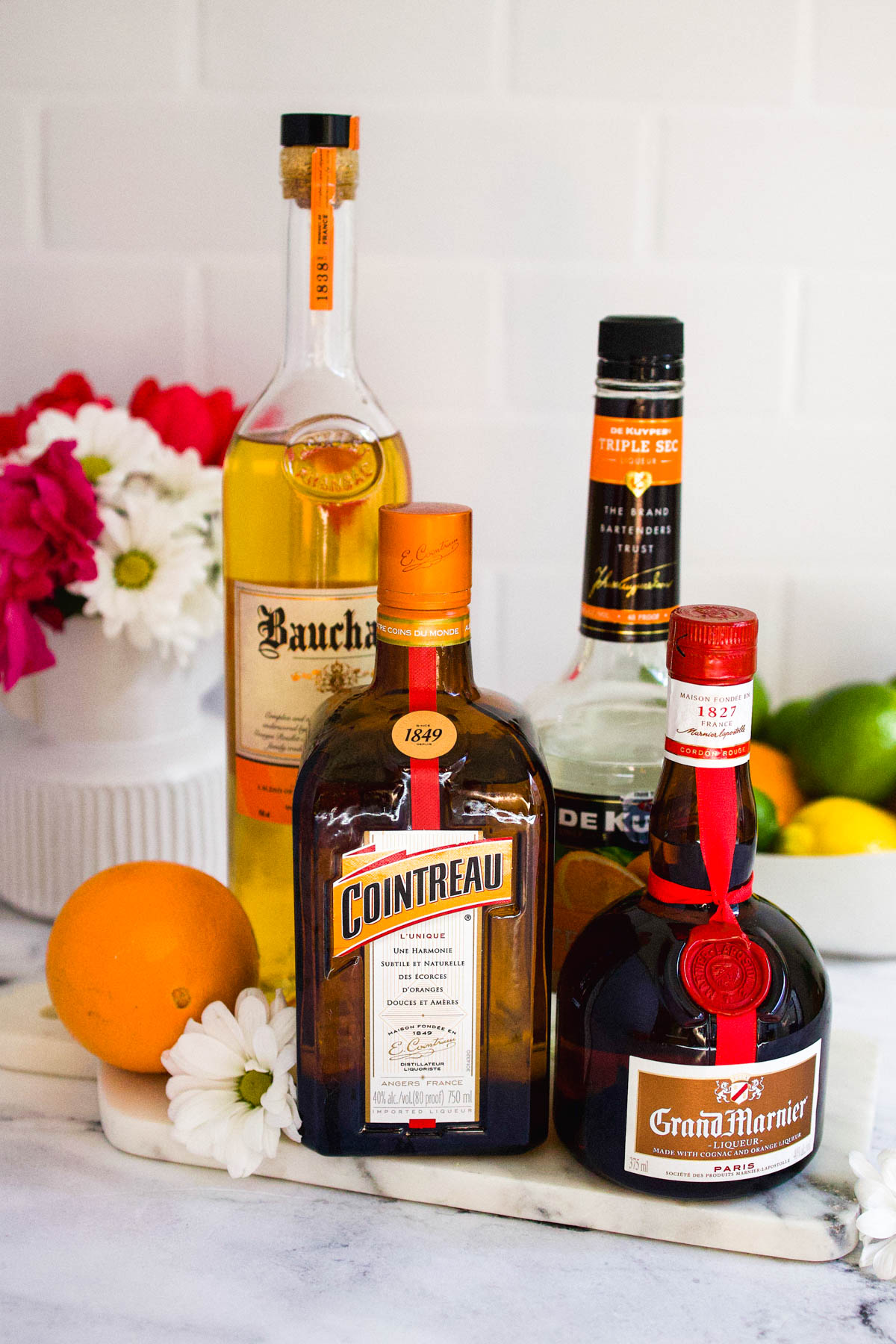 Different bottles of orange liqueur on a table to be used for making margaritas.