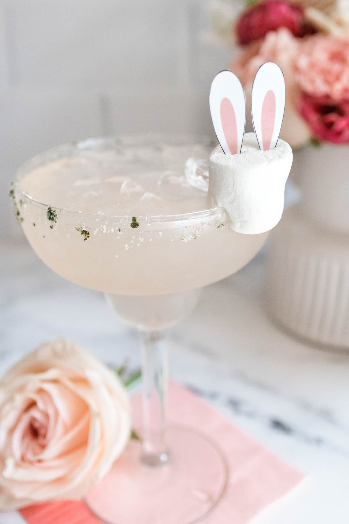 Strawberry Lemonade margarita in a margarita glass with a bunny ear garnish for Easter.