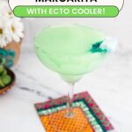 Text: Ghostbusters Margarita with Ecto Cooler with a green frozen margarita in a glass with fun blue garnish.