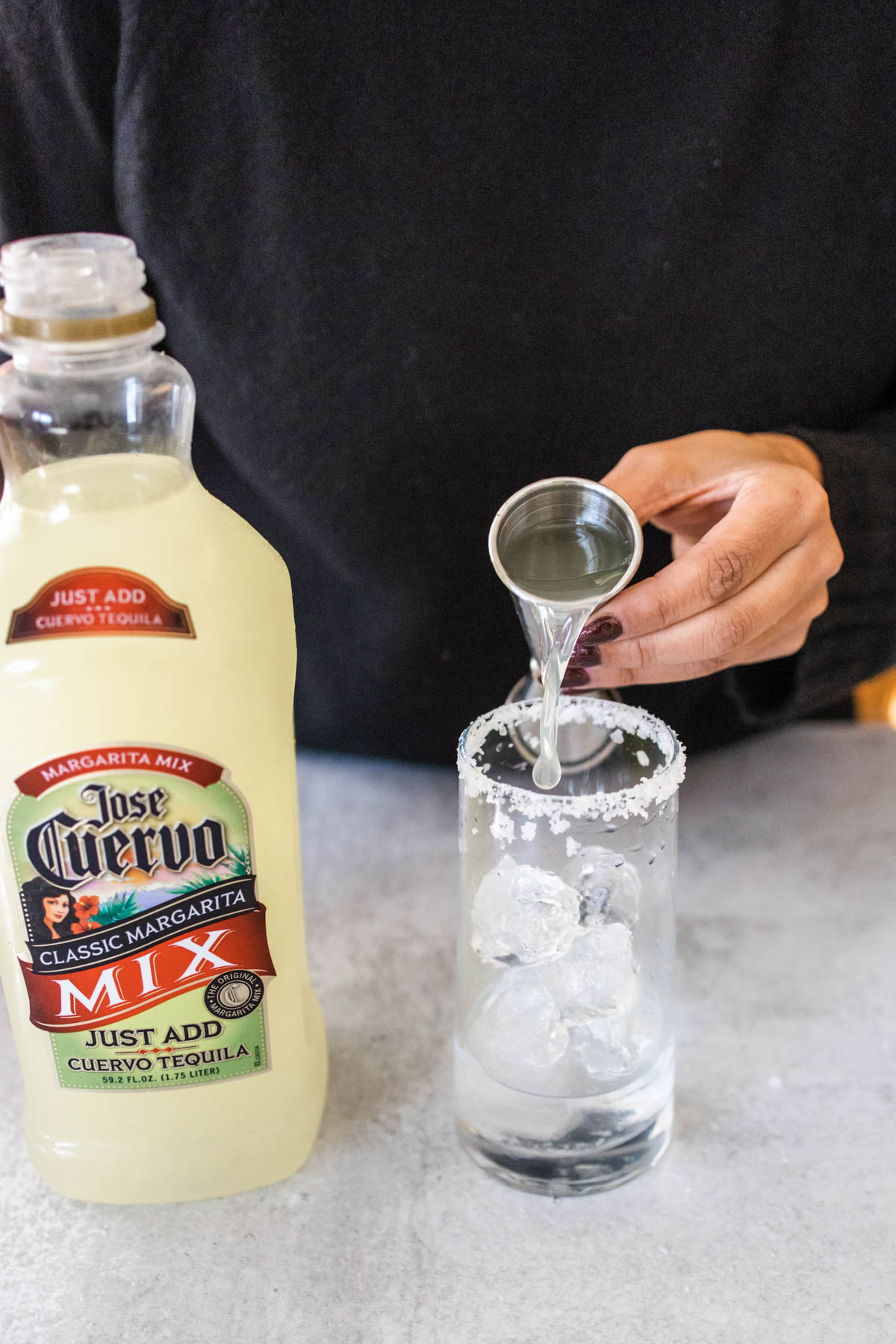 Jose Cuervo margarita mix in a jigger and poured into a cocktail glass with a salt rim.
