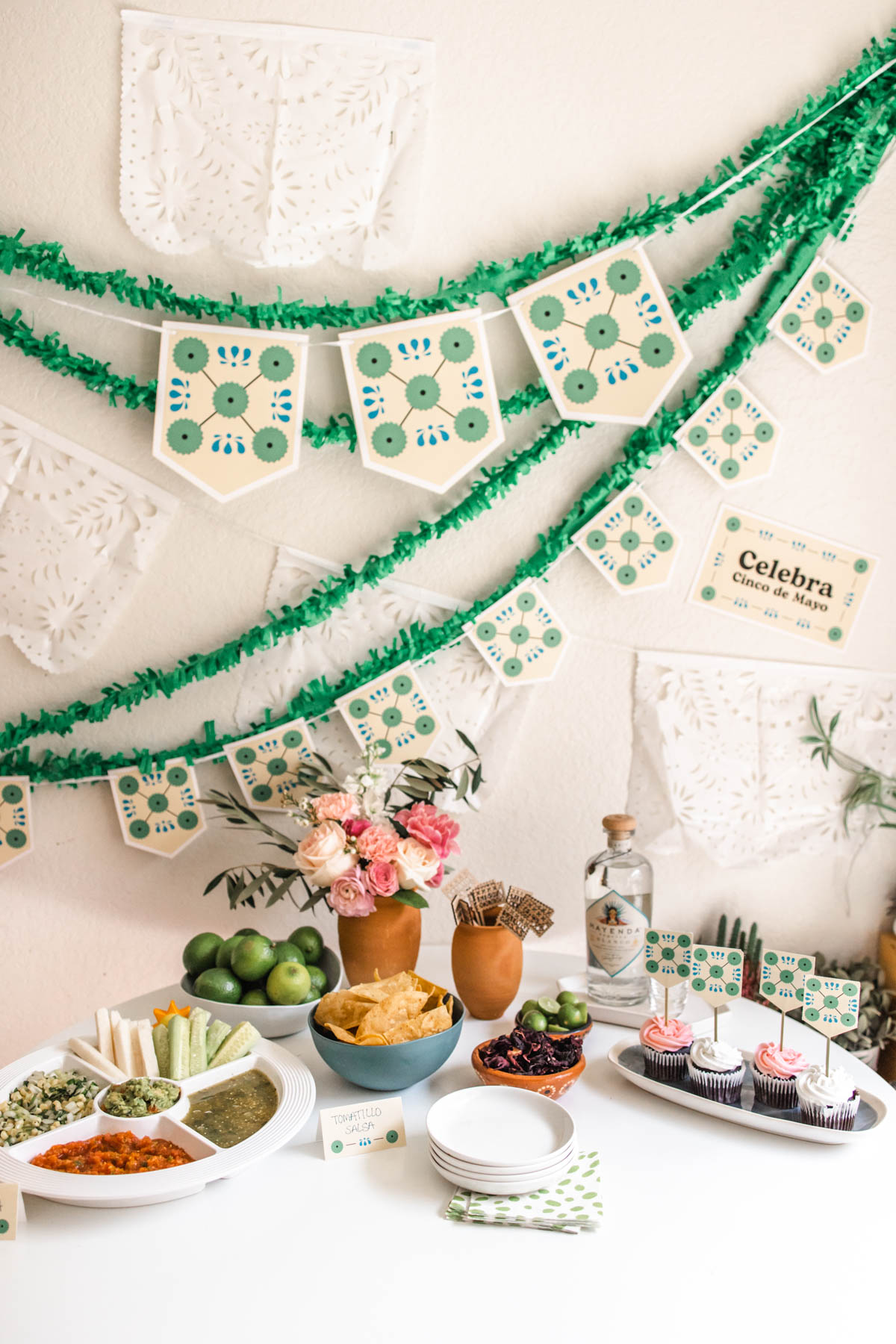Cinco de Mayo printable party decorations on a wall and food table. 