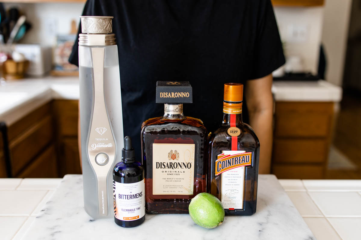 A bottle of Tequila Gran Diamante, Disaronno Originale, Cointreau, Fresh lime, and Bittermens Elemakule Tiki Bitters.