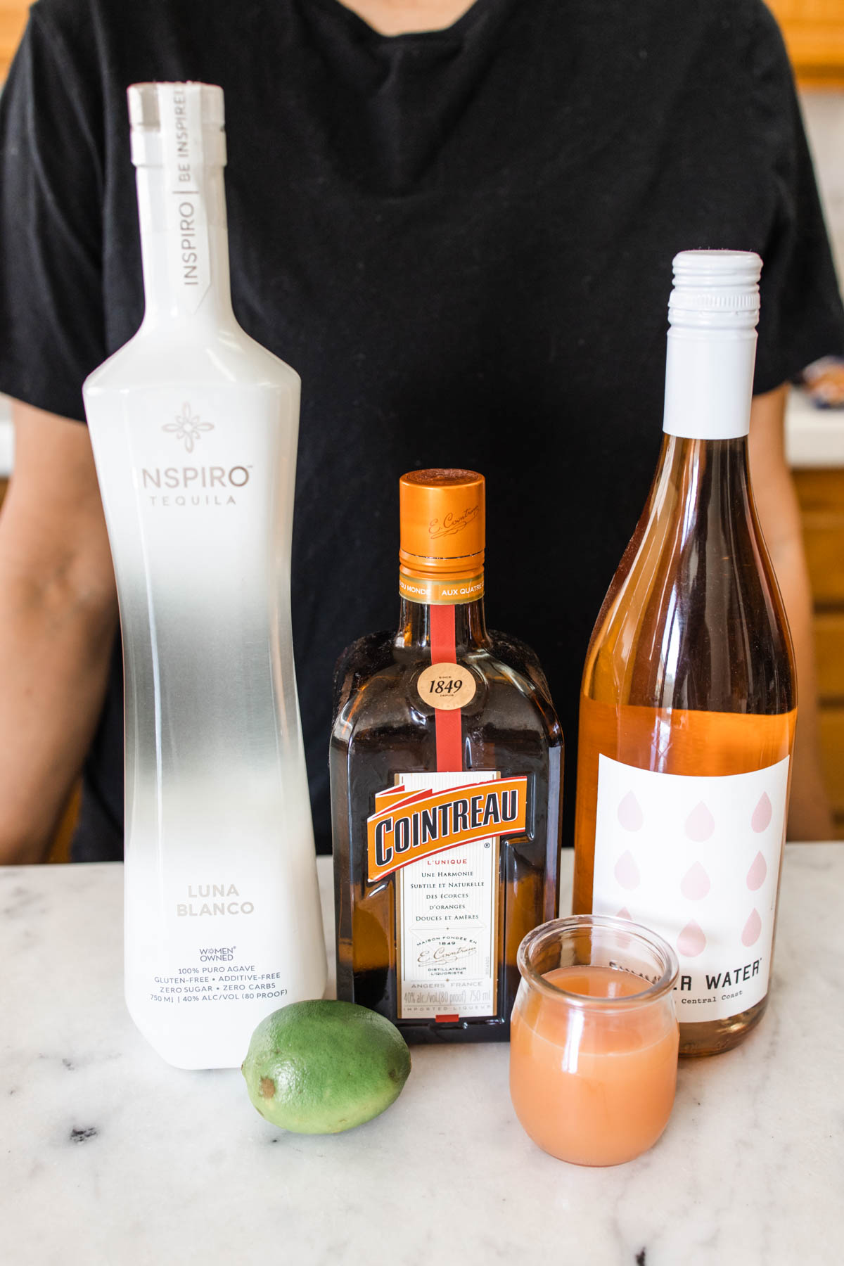 A bottle of Inspiro tequila, Cointreau, rose wine, fresh lime, and grapefruit juice.