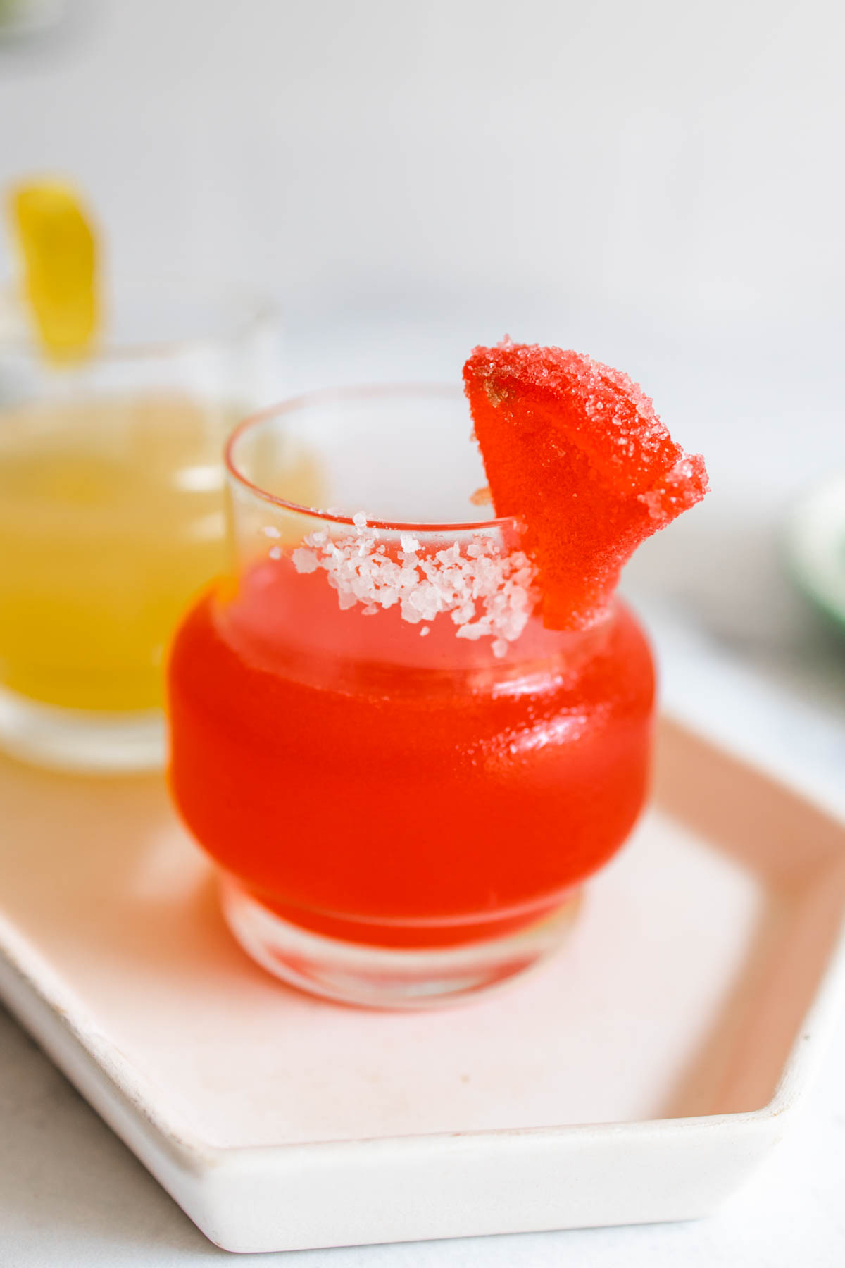 A close-up shot of a beautifully red Deadpool margarita inside a small salt-rimmed glass.