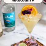 An orange-salted rim glass of Lillet Margarita garnished with orange slice and edible flower with the text "Lillet Margarita" on top.