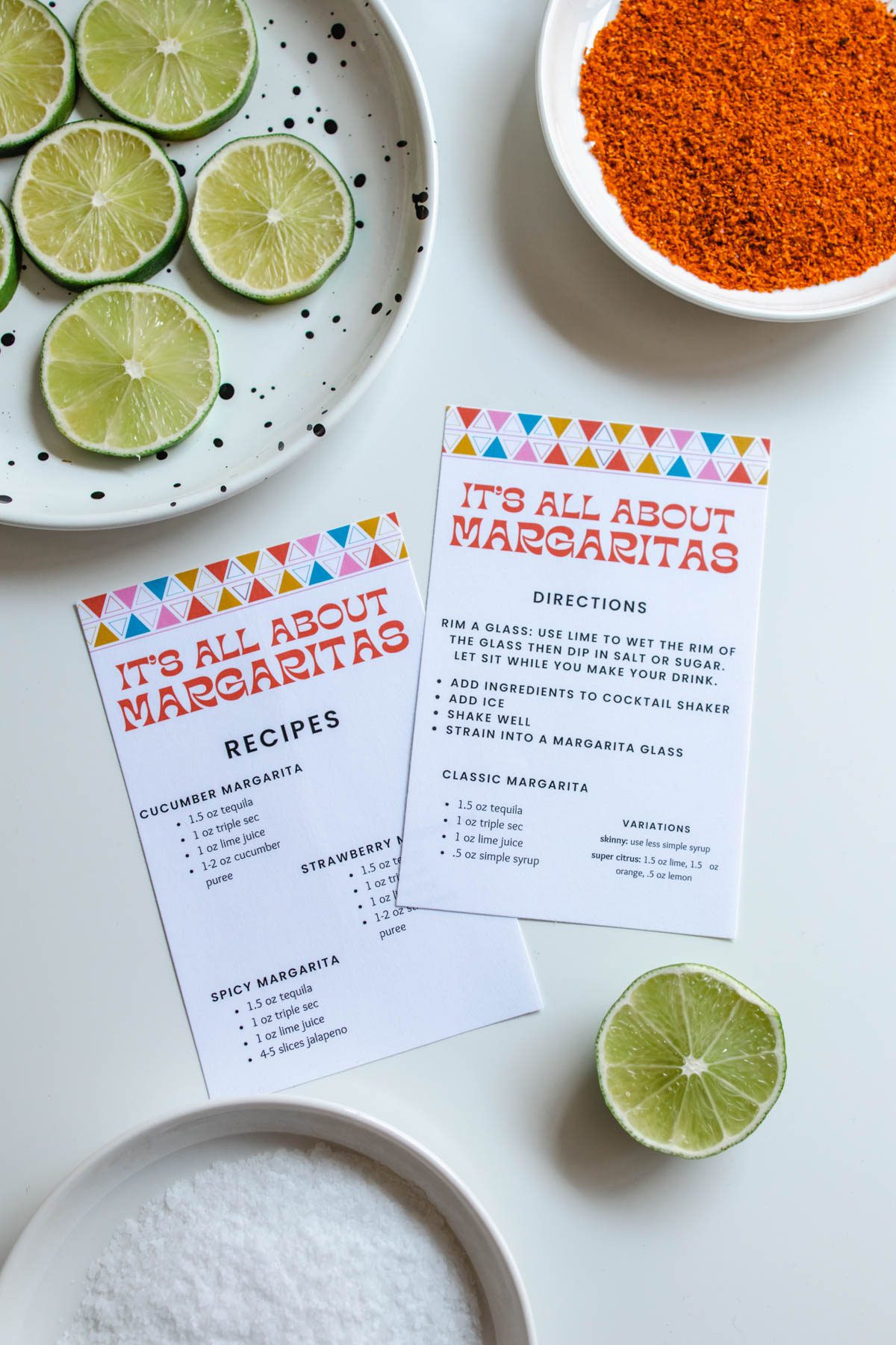 Two plates of sliced limes and Tajin with printables of recipes and directions on how to make margaritas below them.