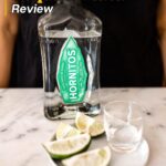 A bottle of Hornitos Tequila Plata behind a plate of lime wedges with the text "Hornitos Tequila Plata Review" on top.